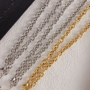 Close-up of gold and silver stainless steel cable chains with lobster clasp details