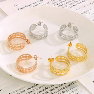 Boucles d'oreilles C ajourées à trois rangs en or, argent et or rose sur une assiette