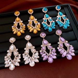 Detailed macro of crystal teardrop earrings in amber, blue, white, and purple