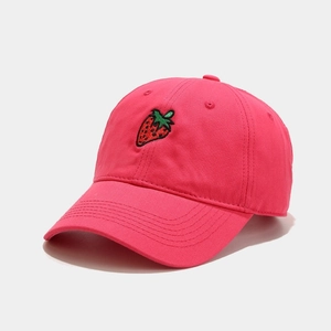Close-up of pink baseball cap featuring detailed strawberry embroidery and cotton texture
