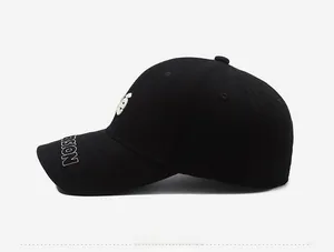 Close-up of side view detailing white 3D embroidery on a black cotton baseball cap