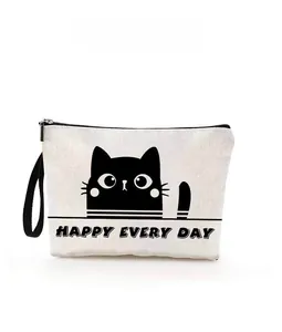 Close-up of a white canvas makeup bag with a black cat design and zipper detail