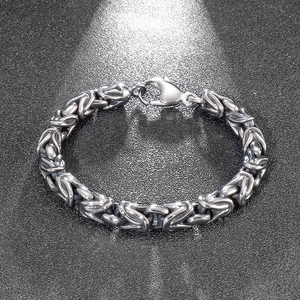 Macro detail of men's Byzantine chain bracelet with intricate silver steel link weave