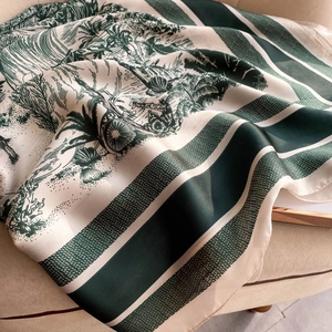 Detailed texture of beige and dark green floral silk scarf on soft fabric background