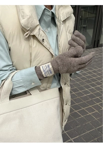 Detail of dark brown wool knit long gloves with vintage fabric label on the wrist