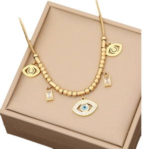 Golden stainless steel turquoise eye necklace with zircons on a beige jewelry box