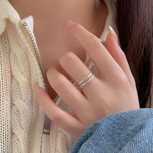 Detail of 925 sterling silver pig nose anchor chain ring worn by a model in casual style