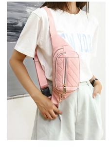 Detail of pink quilted nylon crossbody bag featuring multi-pocket design and adjustable strap