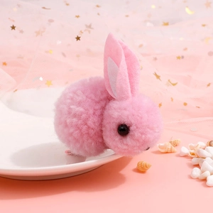 Detailed view of a cute pink plush bunny hair clip placed on a decorative white plate