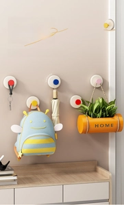 Vacuum suction cup hooks holding keys, bag, umbrella and plant on an entryway wall