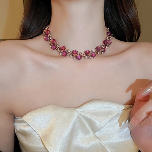 Detail view of a vintage flower necklace set with pink cat eye stones on a model
