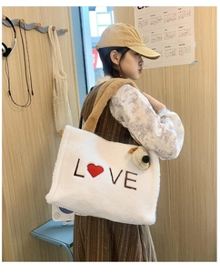 Detail of white plush tote bag with LOVE embroidery and cute dog plush charm pendant