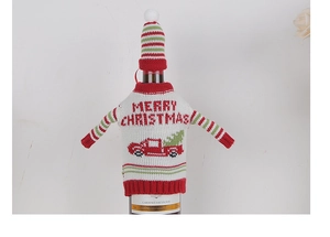 Detail of red Merry Christmas knitted wine bottle cover with festive truck and tree design