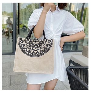 Close-up of bohemian linen tote with black mandala print and braided handle detail