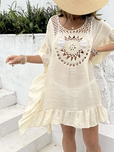 Detail of bohemian crochet beach cover-up featuring intricate circular knit patterns and ruffles