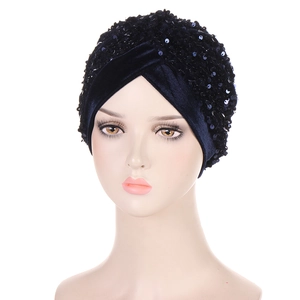 Detail of navy blue velvet turban cap with shimmering sequins and pleated design