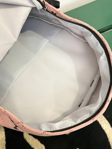 Internal view of pink corduroy backpack featuring a spacious white lined compartment