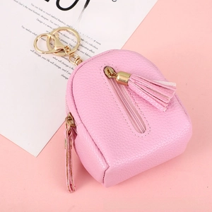 Detailed view of pink lychee leather mini backpack coin purse with gold keychain and tassel