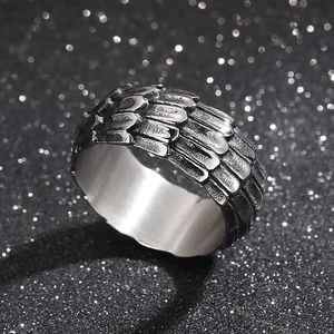 Macro shot of punk style stainless steel ring with dragon scale texture on black glitter