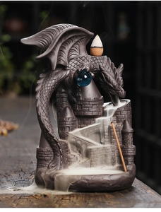 Detailed view of a ceramic dragon backflow incense burner with smoke flowing down a castle