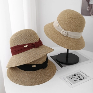 Détails des chapeaux cloches en paille avec rubans en tissu et plaques logo dorées