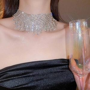 Detailed view of silver rhinestone fringe necklace worn on a neck in a luxury setting
