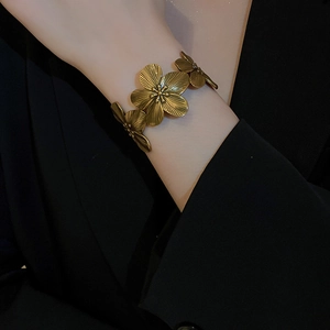 Close-up of vintage golden flower open cuff bracelet with detailed petal textures