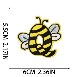 Detail of bee letter Q embroidered patch with dimensions 5.5x6cm on white background