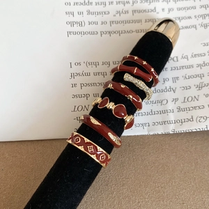 Detail of red enamel 14k gold plated rings set with star and bamboo motifs