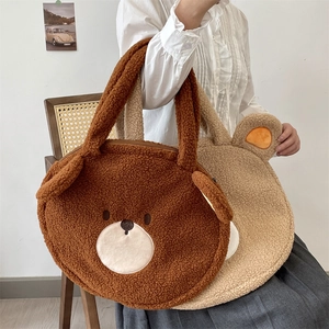 Detail of plush teddy bear tote bags in brown and beige with embroidery and fluffy ears