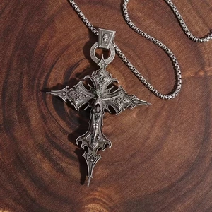 Gothic cross necklace with skull motifs and engraved Die Last text on dark wood background