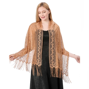 Close-up of golden lace shawl featuring intricate hollow patterns and delicate tassels