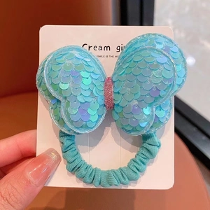 Detail of sequin butterfly hair tie with blue iridescent finish and elastic fabric band