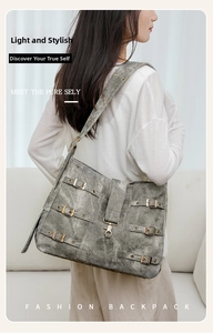 Detail of grey crossbody tote with metallic buckle straps and vintage industrial design