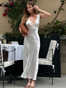 Detail of white satin maxi dress with V-neck lace trim and silky texture finish