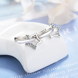 Macro shot of silver hollow star earrings with white cubic zirconia inlay for women