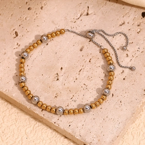 Detailed close-up of two-tone gold and silver beaded bracelet with adjustable slider clasp