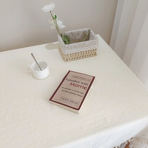 Détail de la texture d'une nappe en coton et lin beige avec des bordures à franges