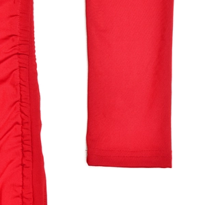 Détail de la robe rouge montrant le design à cordon froncé et les finitions de couture