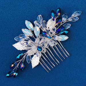 Detailed view of handmade silver bridal hair comb with blue crystals and metal leaves