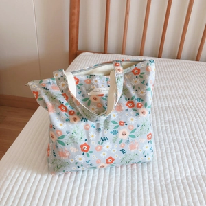 Detail of floral canvas tote bag showing interior zipper and animal patterns label