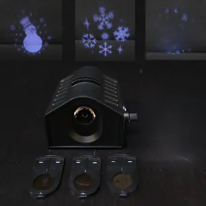 LED Christmas projector light with three slides showing snowman and snowflake patterns