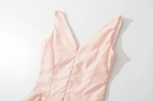 Detail of pink sleeveless satin dress featuring a V-neckline and refined stitched seams
