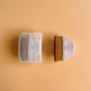 Pink flat-top foundation brush with soft brown bristles and a clear storage case