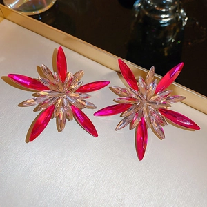 Detail of star-shaped earrings with pink crystal rays and silver needle studs