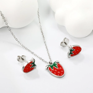Cute strawberry jewelry set with red enamel necklace and earrings on white background