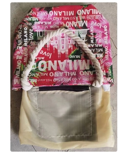 Detail of canvas beach bag featuring MILANO print, rope handles, and internal zipper pocket