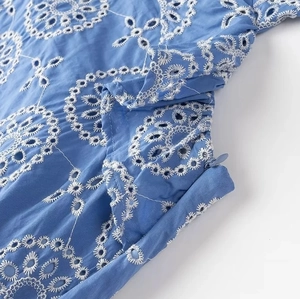 Close-up of white eyelet embroidery and matching hidden zipper on blue midi dress
