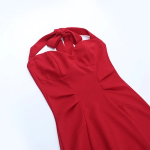 Close-up of red halter dress featuring a detailed tie-neck bow and pleated bodice waist