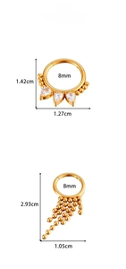 Detail of stainless steel piercing rings with teardrop zircons and gold bead tassels